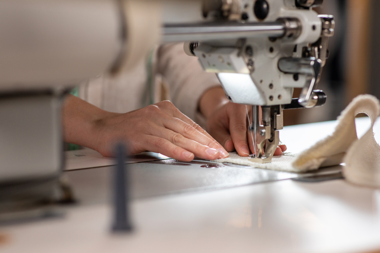 a closeup of a woman using a professional sewing machine