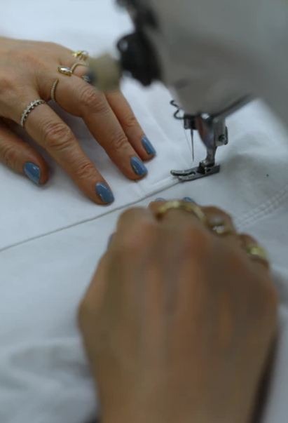 person sewing using a sewing machine
