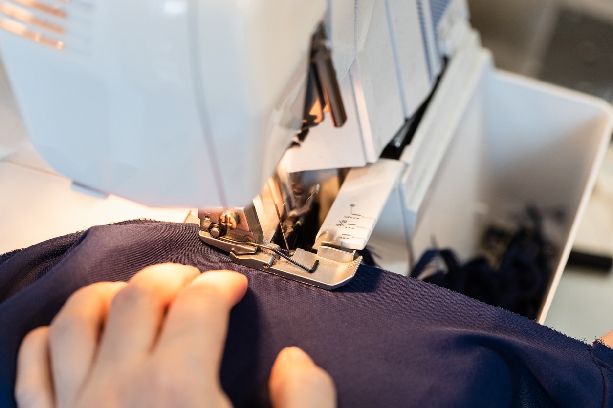 tailor overcasting the edge of fabric on serger