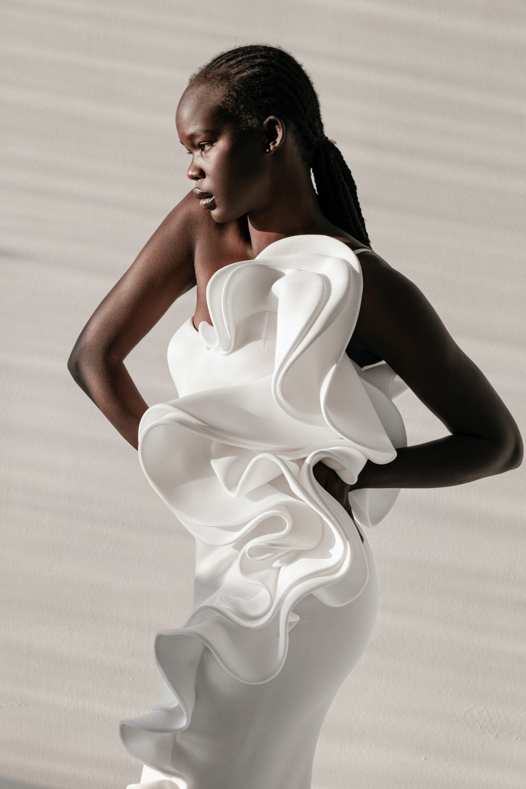 Afro-American female model in a white dress with ruffles