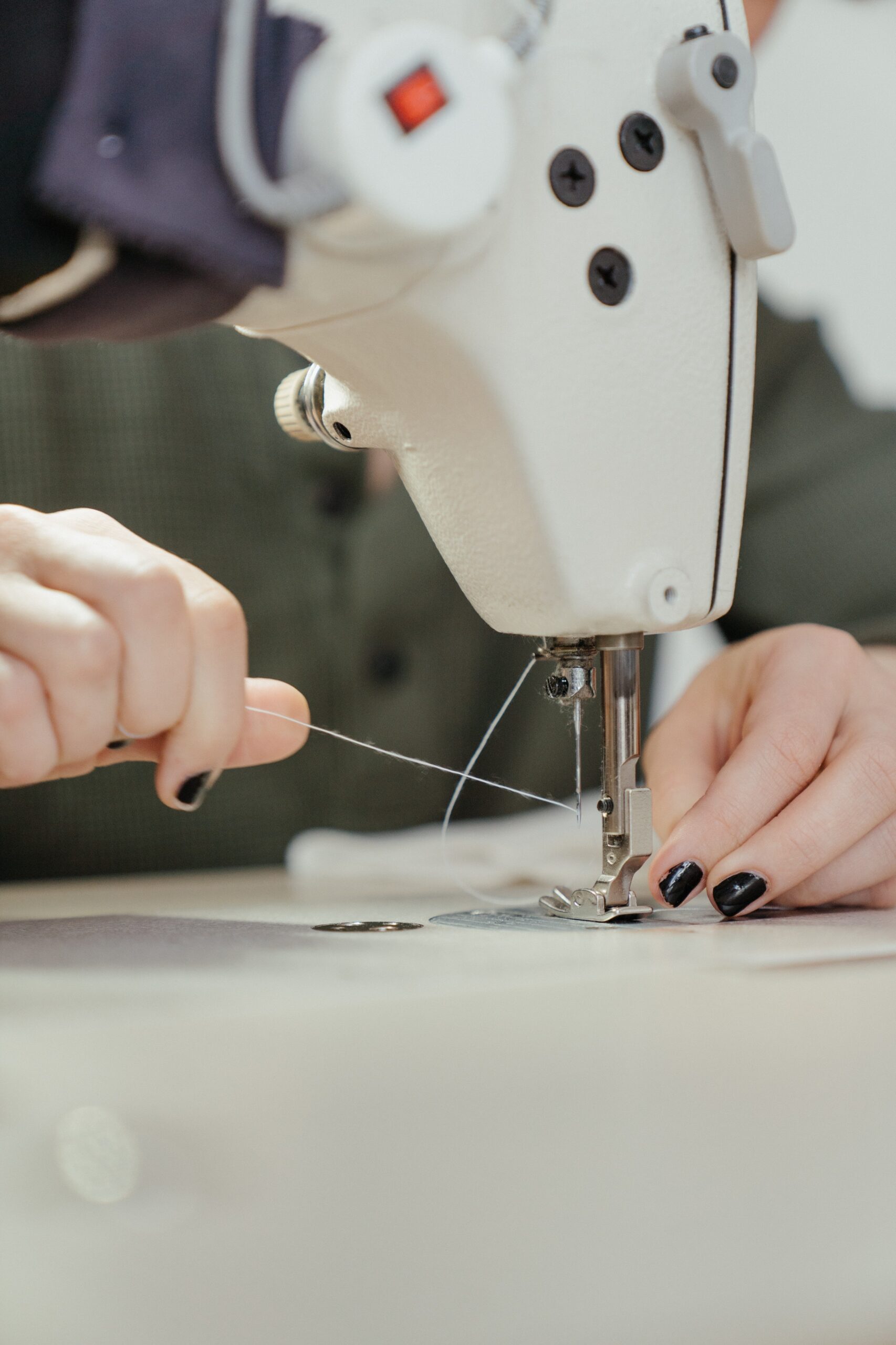 Person sewing a white sewing machine